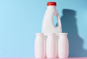 White plastic bottles for yogurt and dairy products on a blue background photo