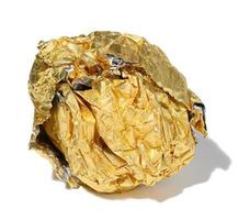 Crumpled piece of golden foil with shadow on a white isolated background photo