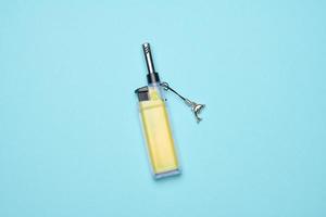 Yellow plastic lighter on a blue background, top view photo