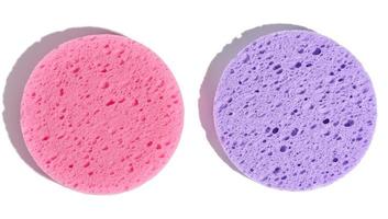 esponjas de maquillaje redondas de color púrpura y rosa sobre un fondo blanco aislado
