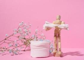 Round cotton cosmetic pads and cotton buds on a pink background photo