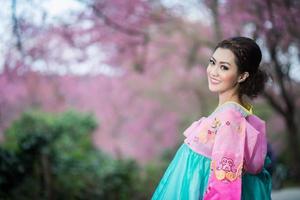 Hanbok, the traditional Korean dress and beautiful Asian girl with sakura photo