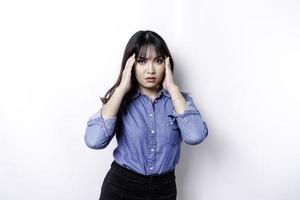 A portrait of an Asian woman wearing a blue shirt isolated by white background looks depressed photo