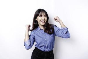 A young Asian woman with a happy successful expression wearing blue shirt isolated by white background photo