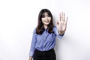 hermosa mujer asiática con camisa azul con pose de gesto de mano de parada o prohibición con espacio de copia foto