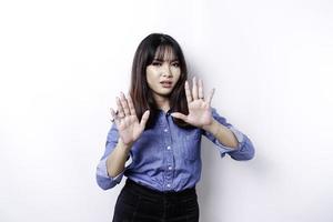 Young Asian woman isolated on white background, looks depressed, face covered by fingers frightened and nervous. photo