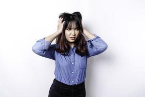 A portrait of an Asian woman wearing a blue shirt isolated by white background looks depressed photo