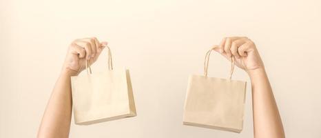 Woman hands carrying brown paper shopping bag. Concept of using recycle material to save the world and decrease pollution. photo