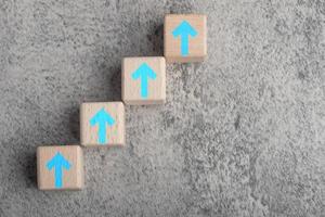 wooden blocks arranged stairs. concept curved line of arrow rising step up the stair to target as metaphor for business and financial growth, Success in future photo