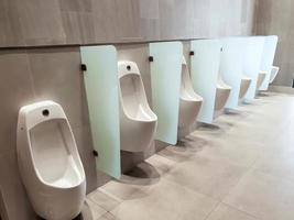 Perspective view of men urinal with automatic cleaning system in public toilet of shopping mall. photo