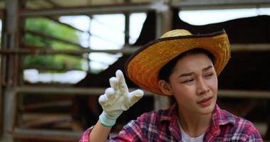 Pretty agricultural cattle farmer sitting and take off hat and wiping sweat with tiredness in heat weather video