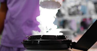 Hands of young veterinarian man in uniform opens a Cryogenic container with medical samples, and pick up frozen stem cells in containers removed from a nitrogen barrel video