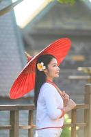 Asian woman wearing typical thai dress with red umbrella.,Thai costume photo