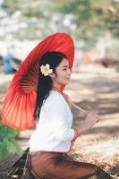 Asian woman wearing typical thai dress with red umbrella.,Thai costume photo