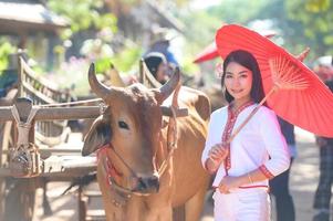 Asian woman wearing typical thai dress with red umbrella.,Thai costume photo