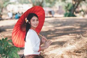Asian woman wearing typical thai dress with red umbrella.,Thai costume photo