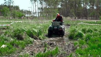 team race through the swamp on an ATV