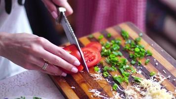 girl cuts vegetables at the kitchen video