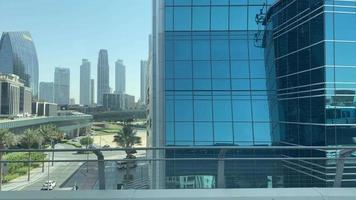 dubai, emiratos árabes unidos, 2022 - punto de vista de los pasajeros del metro a los edificios comerciales de vidrio del paisaje urbano a la luz del día. viaje al trabajo y explore los viajes en los emiratos árabes unidos video