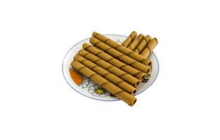 Chocolate or coffee flavored wafers rolls on white dish png