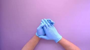 el médico joven usa guantes médicos de látex, flatlay sobre fondo púrpura video