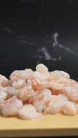Raw shrimp on yellow surface and black marble background video