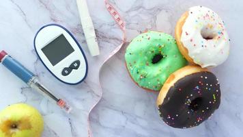 herramientas de medición para diabéticos, pluma de insulina y donuts sobre la mesa, flatlay