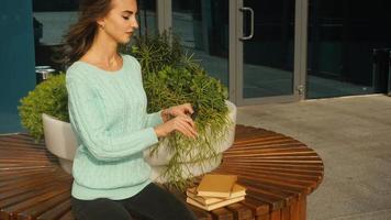 young cheerful woman in glasses reading a book in the street video