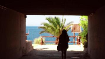 junges Mädchen geht durch den Tunnel zum verschwommenen Hintergrund des Meeres