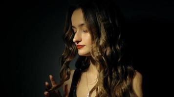 Wunderschöne junge Dame mit lockiger Frisur im dunklen Studio video