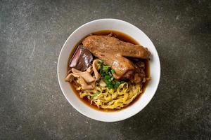 egg noodles with stewed and braised duck in brown soup photo