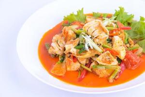 comida favorita tailandesa. revuelva los calamares fritos con curry en el plato blanco. foto