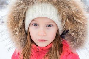 retrato de una niña adorable en un día soleado de invierno nevado foto