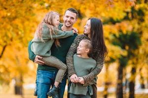 retrato de familia feliz de cuatro en otoño foto