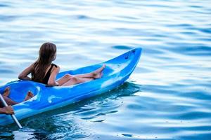 Sporty attractive family kayaking on sea together photo