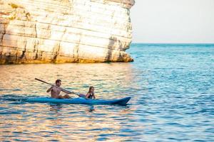 familia deportiva atractiva en kayak en el mar juntos foto