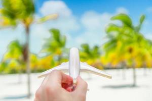 Little white toy airplane on background of turquoise sea photo