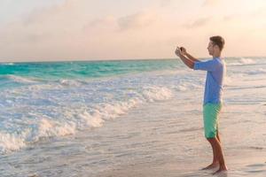 Young man on the white tropical beach photo