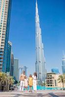 familia feliz caminando en dubai con rascacielos en el fondo. foto