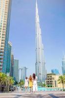 familia feliz caminando en dubai con rascacielos en el fondo. foto