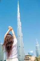 Happy woman walking in Dubai with skyscraper in the background. photo