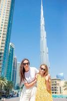 familia feliz caminando en dubai con rascacielos en el fondo. foto