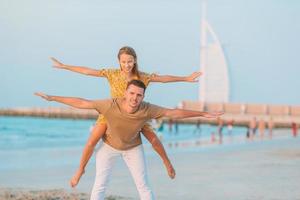 Little girl and dad silhouette in the sunset at the beach photo