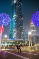 niña feliz caminando en dubai con rascacielos en el fondo. foto