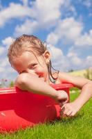 retrato de una niña encantadora y sonriente disfrutando de sus vacaciones en la piscina al aire libre foto