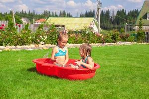 dos hermanitas jugando y chapoteando en la piscina en un día caluroso y soleado foto