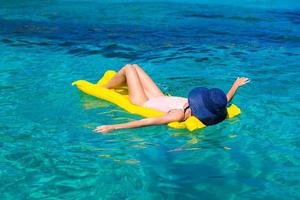 Woman relaxing on inflatable mattress in the sea photo