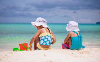 Little girls playing with beach toys during tropical vacation photo