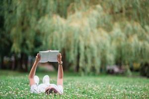 Relaxed young woman reading book photo