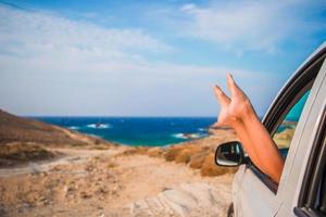 vacaciones de verano, vacaciones, viajes, viaje por carretera y concepto de personas - cerca de los pies de las niñas que se muestran desde la ventana del auto foto